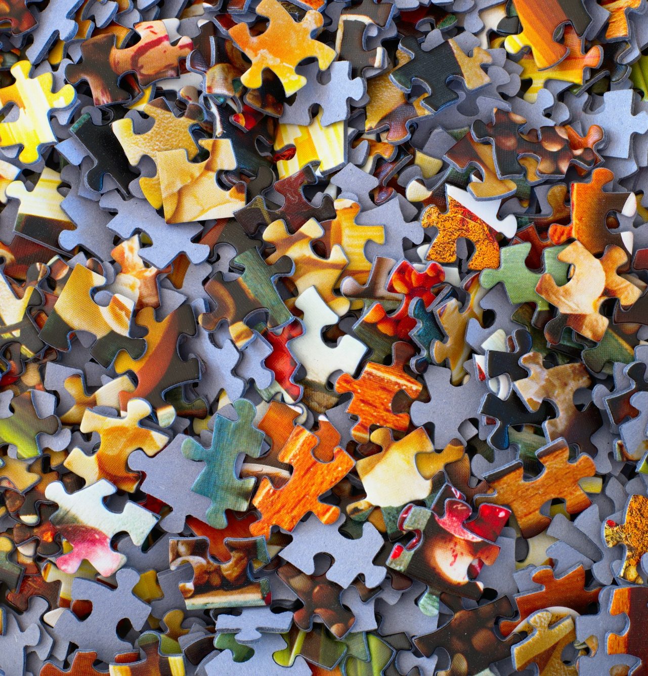 Symbolfoto Puzzle Bunte Puzzle-Teile liegen chaotisch auf einem Tisch verstreut.